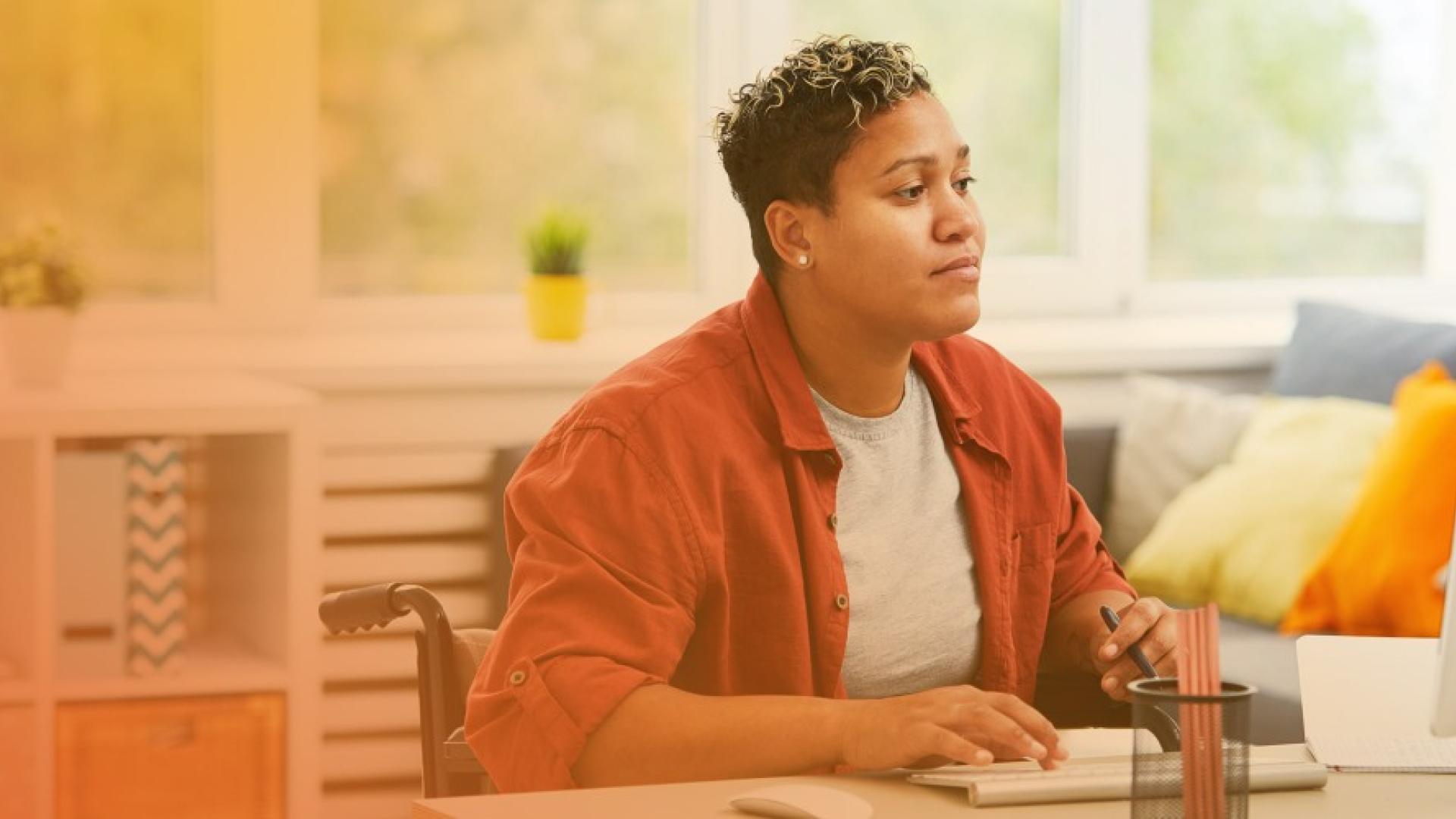 Woman in wheelchair using computer at work