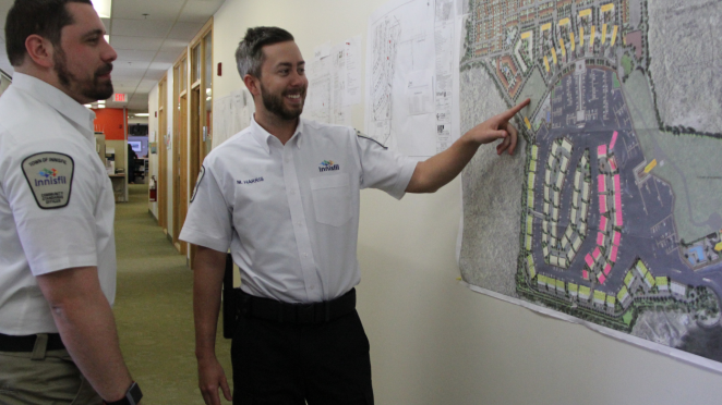 Two municipal law officers looking at a map