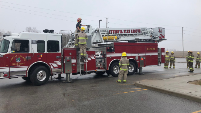 Innisfil fire truck with firefighters standing around it