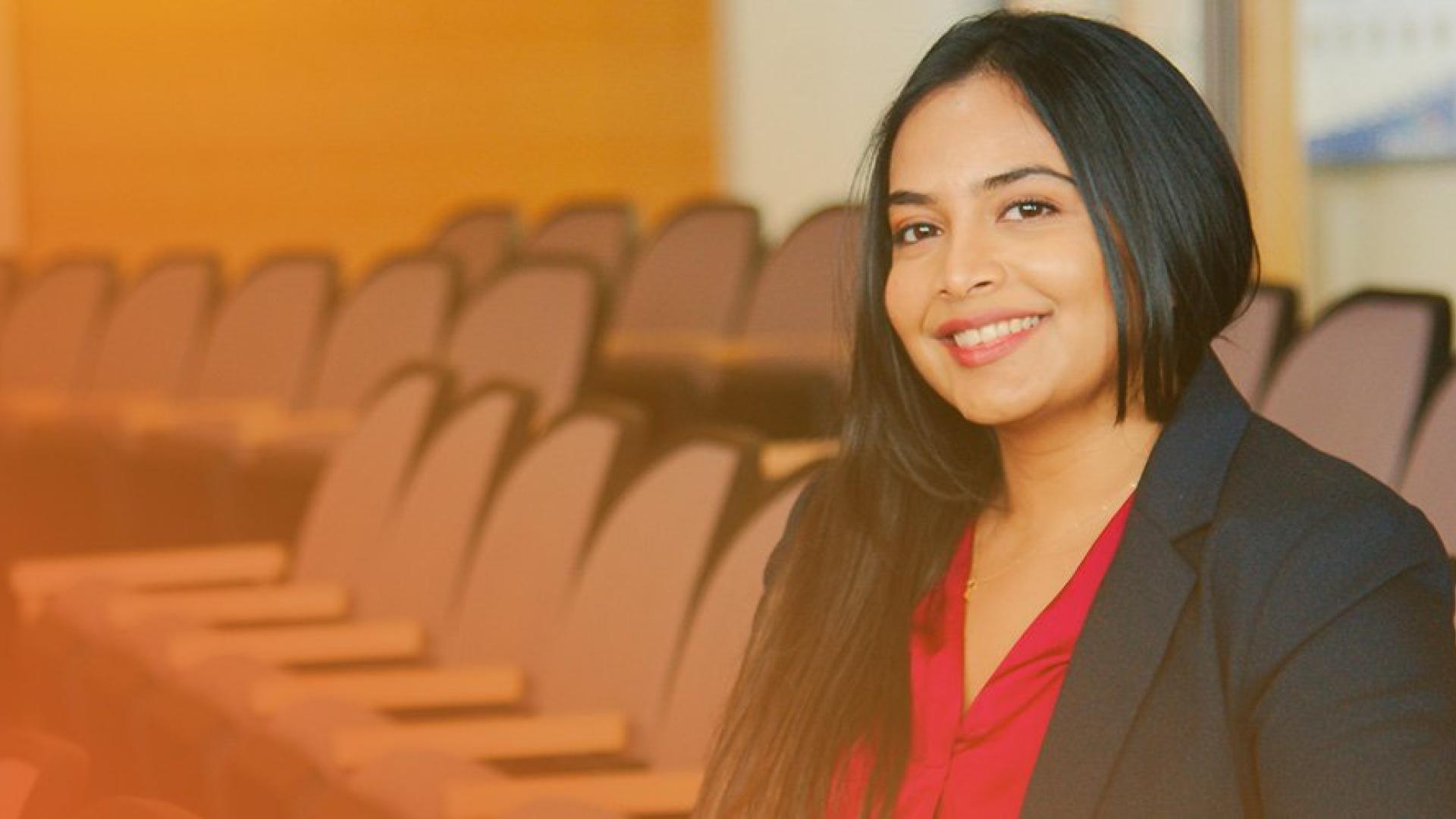 smiling development engineer seated in the Town's Council Chambers