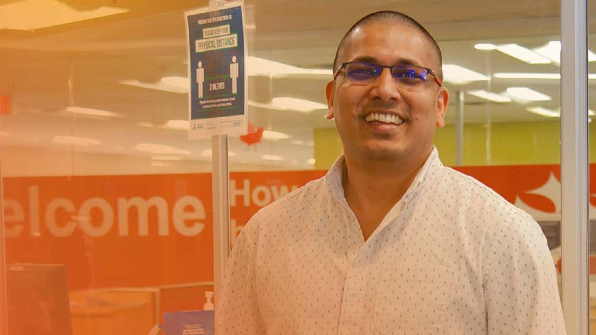 smiling customer service staff member standing in front of customer service window