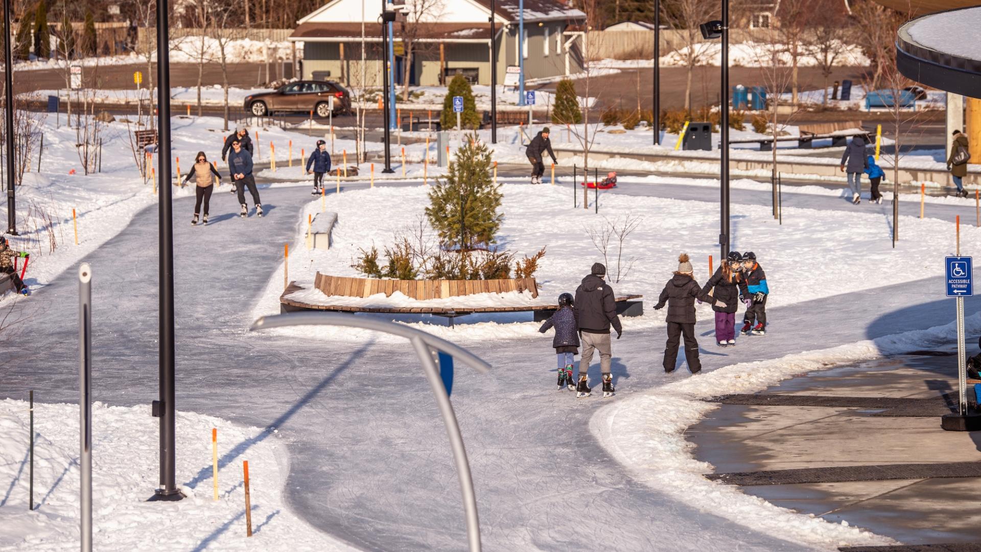 Aerial shot of park with large ice skating trail and people skating
