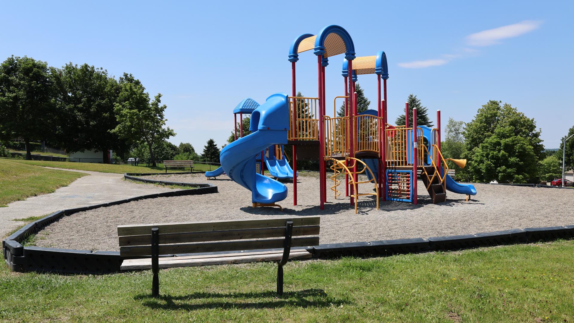 Park bench and colourful playground equipment