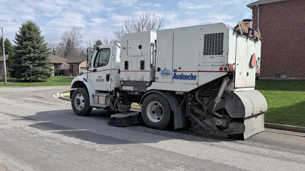 Street sweeper driving down residential street
