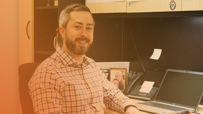 Town employee sitting at desk smiling