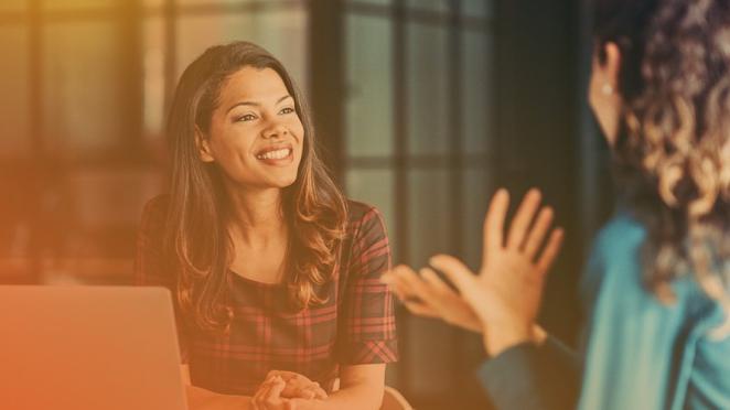 two employees having a conversation and smiling