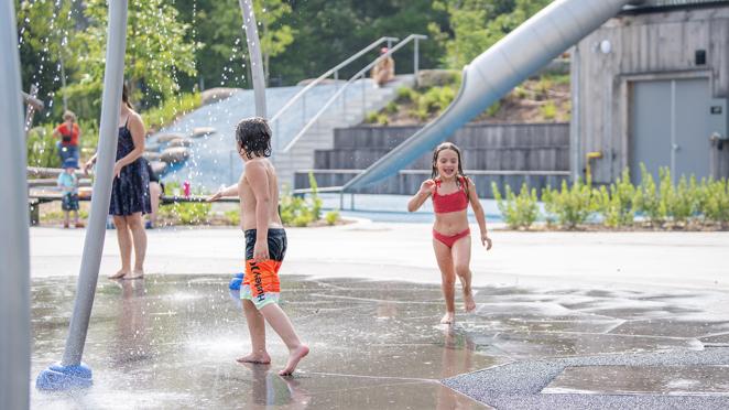 Children in bathing suits enjoying a hot summer day in splash pad