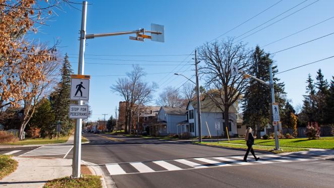Woman safely crossing the street at a pedestrian crossover