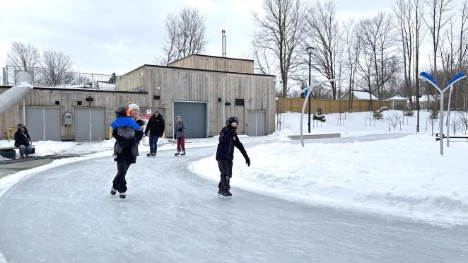 Children and adults skating outdoor on an ice track at Innisfil Town Square