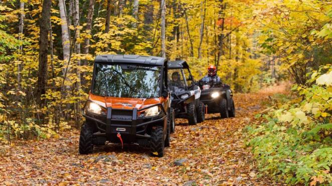 Off-road vehicles driving on a forest trail in the fall
