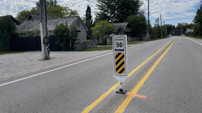Bollard showing 50 km per hour in middle of the road to slow traffic