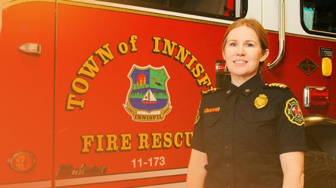 Smiling deputy fire chief standing in front of fire truck