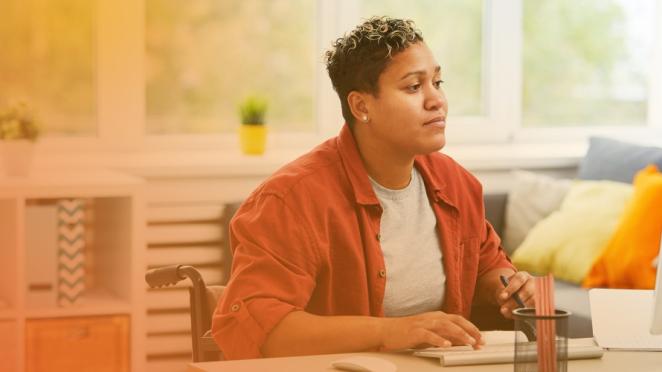 Woman in wheelchair using computer at work