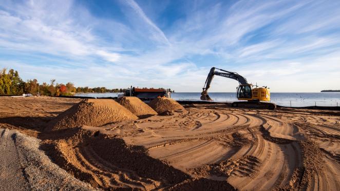 Construction equipment adding sand to beach at Innisfil Beach Park