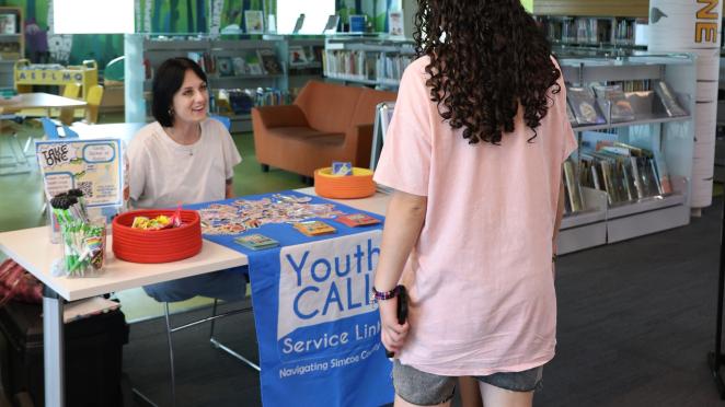 Teen asking YouthCALL about counselling services at the library