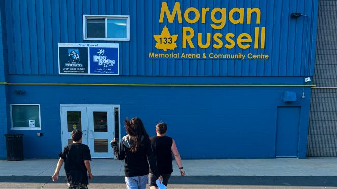 Three teens excitedly running toward the Morgan Russell Arena and Community Centre