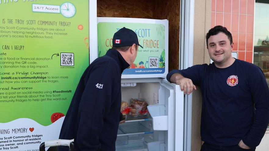 Firefighters putting food in community fridge