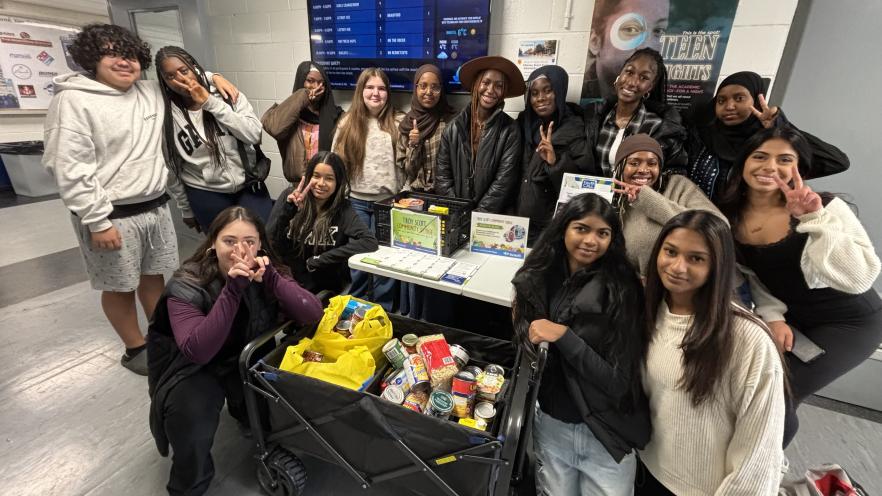 Teens posing with large food donation
