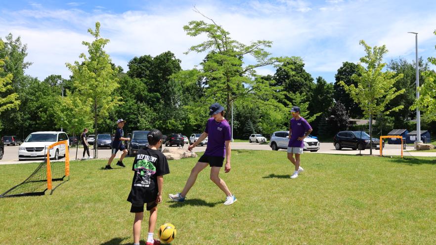 Mobile Youth Centre staff playing soccer with youths
