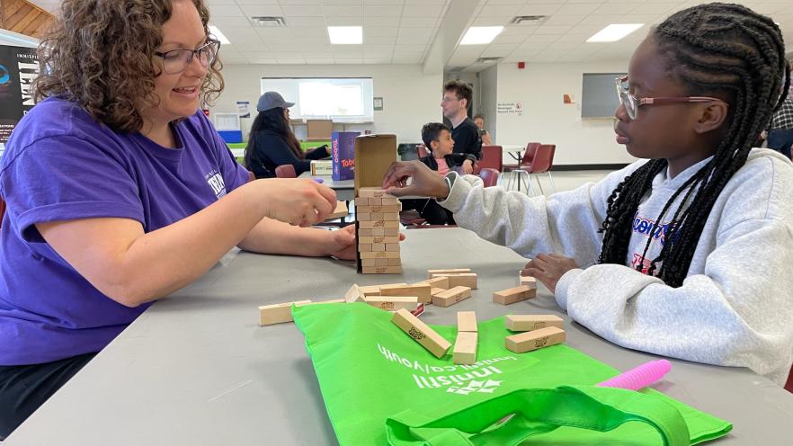 Teen Nights staff playing Jenga with a teen girl