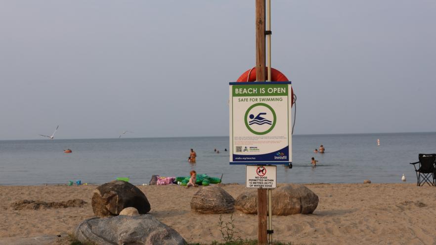 Sign at beach showing the water is safe to swim in