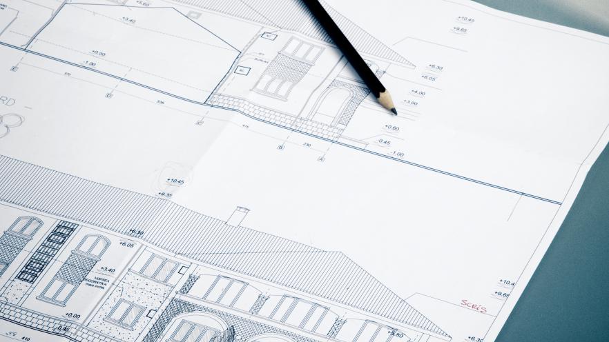 Blueprint drawing of a house with a pencil
