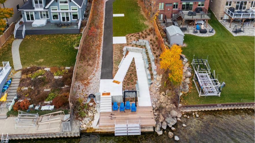 Arial photo of a wooden dock on the water with a narrow park linking it to the nearby road