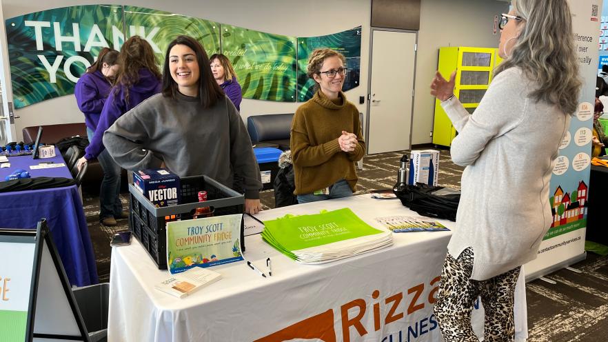Two people at an information table providing resources to resident
