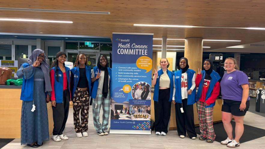 Group of Youth Connex Committee members posting with zip banner