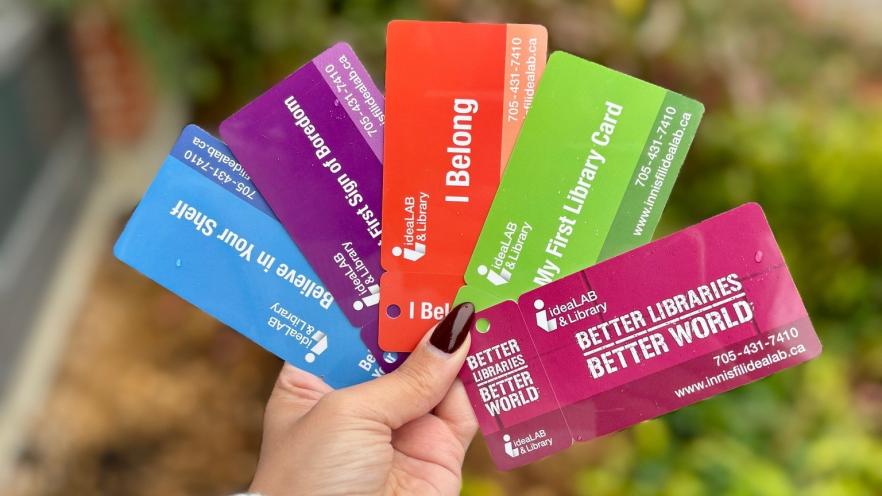 Woman holding several Library cards in hand