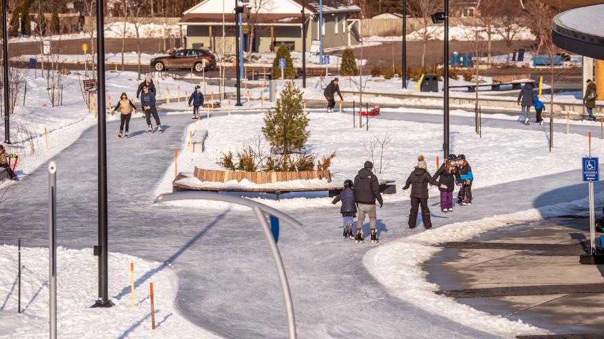 Aerial shot of park with large ice skating trail and people skating