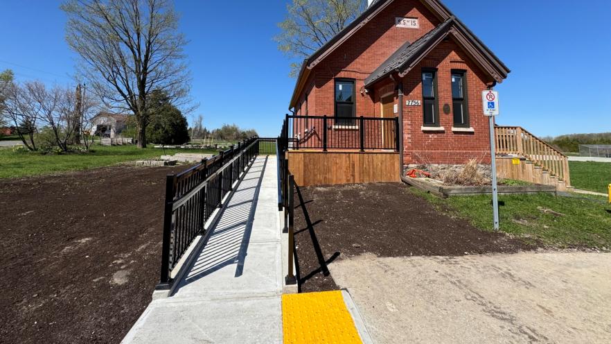 Outside of historic building on sunny day, featuring an accessible ramp at the entrance