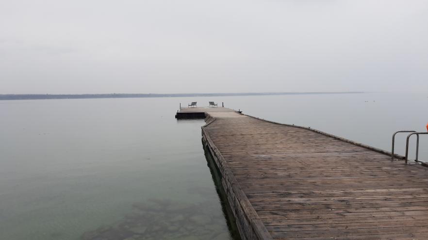 Wooden dock extending into an overcast Lake Simcoe