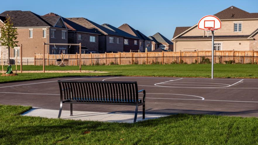 Park bench and outdoor basketball half-court at new park