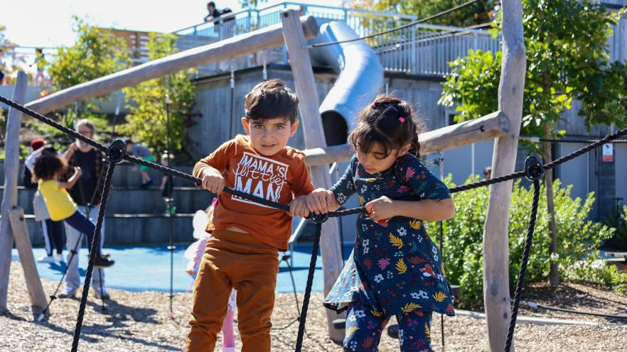 Siblings climbing play equipment at park during InnisFALL