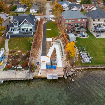 Arial photo of a wooden dock on the water with a narrow park linking it to the nearby road