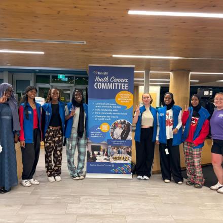 Group of Youth Connex Committee members posting with zip banner