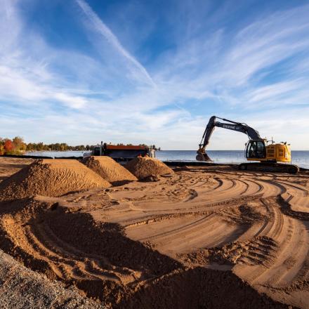 Construction equipment adding sand to beach at Innisfil Beach Park