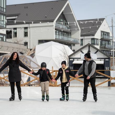 Mom, dad and two children ice skating on promenade at Friday Harbour