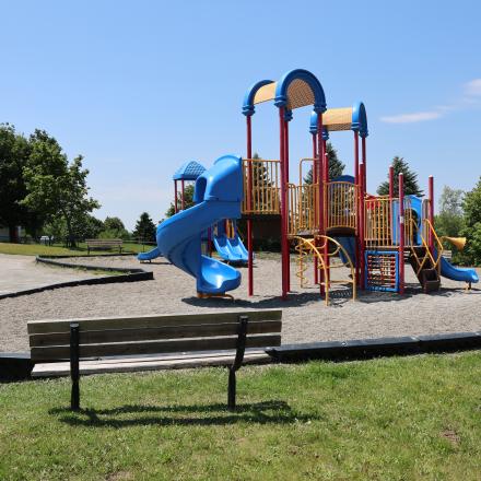Park bench and colourful playground equipment