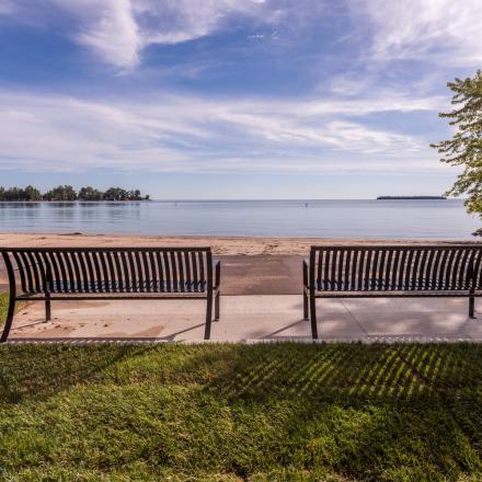 Two benches with lake and sandy beach in front