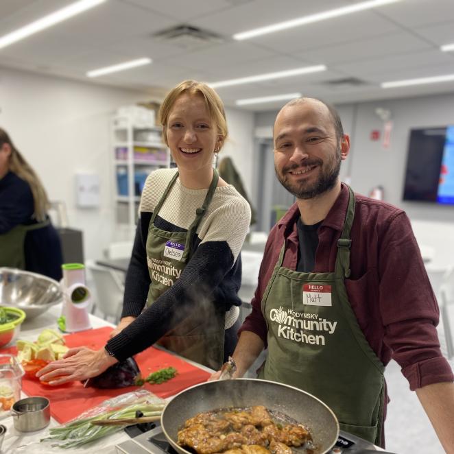 Program participants in cooking class smiling at camera