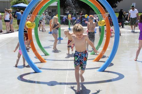 Boy running through ring-like water features
